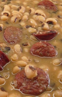 beans and sausage are being cooked in a pot