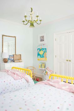 a bed room with a neatly made bed and a chandelier hanging from the ceiling