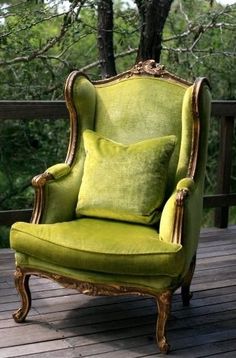 a green chair sitting on top of a wooden deck