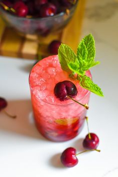 a cherry cocktail garnished with mint and cherries