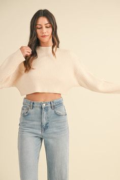 Get ready for effortless layering with the Lauryn Mock Neck Cropped Sweater. This long sleeve, cropped sweater features a chic mock neckline + soft, ribbed material that feels as good as it looks. Its neutral color makes it endlessly versatile—perfect for pairing with your favorite denim or layering over tank dresses to seamlessly transition your wardrobe into Fall + Winter. A must-have for cozy, stylish vibes all season long! Key Features: Long sleeve cropped style Mock neckline Soft, ribbed ma Beige Crop Top Outfit, Crop Tshirt Outfit, Crop Top Outfits Fall, Beige Crop Top, Beige Crop Tops, Tank Dresses, Cropped Long Sleeve, Crop Top Outfits, Crop Sweater