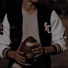 a young man holding a football in his right hand and wearing a jacket with the number 30 on it