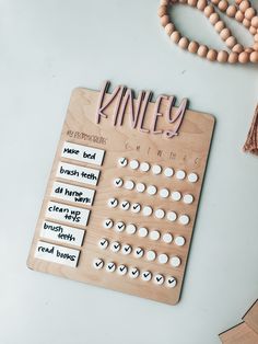 a wooden board with words and numbers on it next to beads, necklaces and a bead necklace