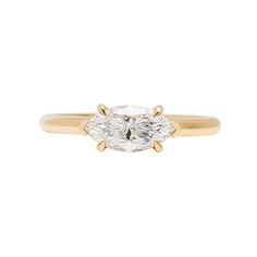 a yellow gold ring with an oval cut diamond