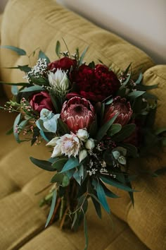 a bouquet of flowers sitting on top of a couch