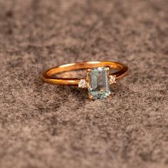 a ring with an aqua blue topazte and two white diamonds on the side