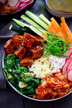 a bowl filled with rice, meat and veggies on top of a table