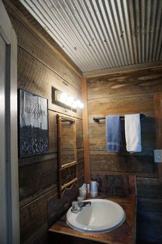 a bathroom with wooden walls and a white sink