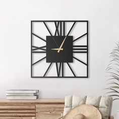 a large clock mounted to the side of a wall next to a chair and table