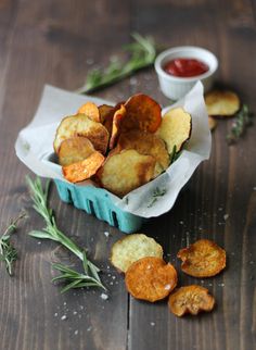 baked potato chips with ketchup and rosemary on the side, ready to be eaten