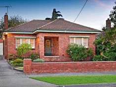 a brick house with green shutters on the front