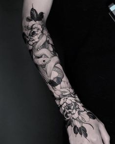 a woman's arm with flowers and birds on it