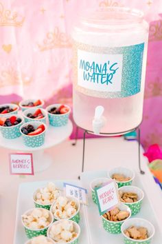 a table topped with cups filled with desserts next to a container of ice cream