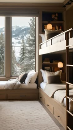 a bedroom with two bunk beds and a large window overlooking the snow covered mountain range