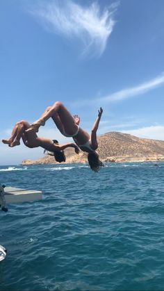 two people diving into the ocean from a boat