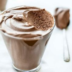 a glass filled with chocolate pudding and a spoon