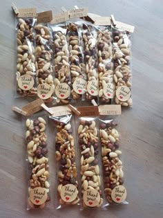 several bags of nuts on a table with thank you note tags attached to the bags