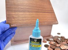 a person in blue gloves is next to some coins and a wooden box with the word paradise on it