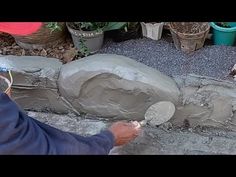 a man is painting the side of a rock