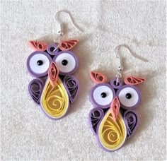 the earrings are made out of paper and have an owl design