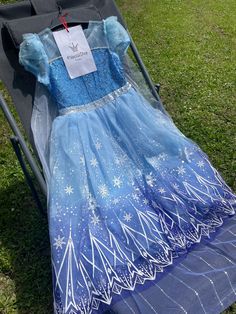 a blue and white dress sitting on top of a stroller