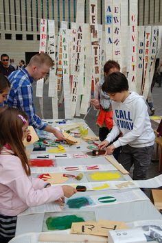 several people standing around a table making crafts