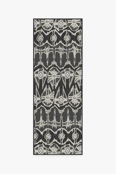 a black and white area rug with an abstract design on the bottom, in front of a gray background