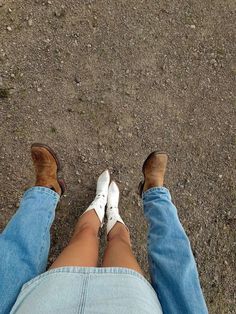 two people sitting on the ground with their legs crossed and one person wearing white shoes