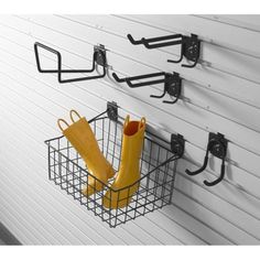 two umbrellas are hanging on the wall next to some metal baskets with yellow umbrellas in them