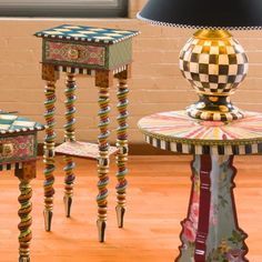 three small tables with different designs on them and a lamp in the corner next to it