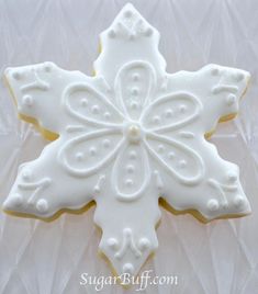 a decorated sugar cookie with white icing on a clear plastic tableclothed surface