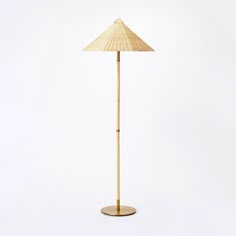 a tall bamboo floor lamp with a wooden base and an umbrella shade on the top