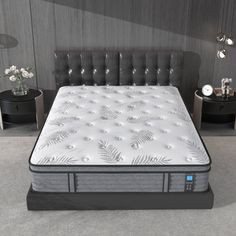 an image of a mattress in the middle of a room with two nightstands and lamps