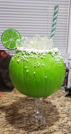 a green drink sitting on top of a counter covered in frosting and sprinkles