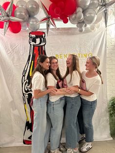 four girls standing in front of a backdrop with balloons