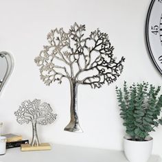 there is a tree on the wall next to a mirror and some plants in vases