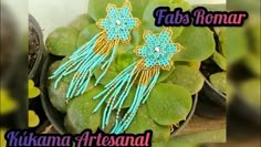 the earrings are decorated with beads and tassels on top of green leafy plants