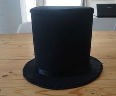 a black top hat sitting on top of a wooden table