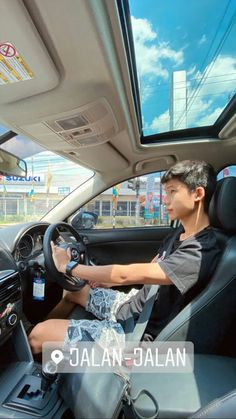 a man sitting in the driver's seat of a car