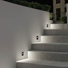 the stairs are lit up at night with dim lights on each step and there is no one in sight