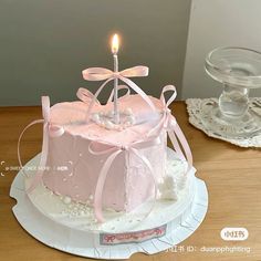 a small pink cake with a candle on top