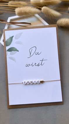 a card with the word'du wirstt'written on it next to some feathers