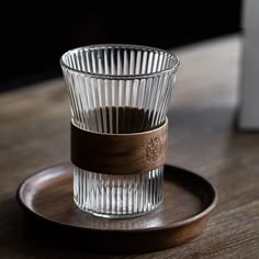 a shot glass sitting on top of a wooden plate