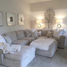 a living room filled with lots of furniture next to a large clock on the wall