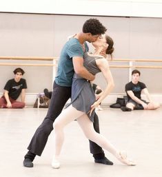 a man and woman are dancing in a dance studio