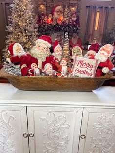 a basket filled with santa clause figurines sitting on top of a white dresser