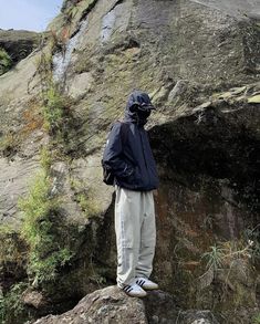 a man standing on top of a large rock