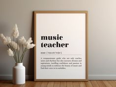 there is a vase with flowers in it next to a poster that says music teacher