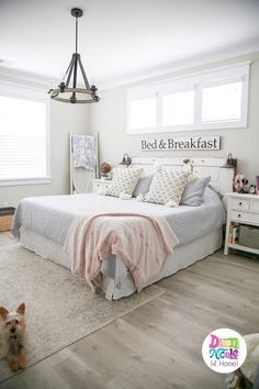 a bed and breakfast sign in a bedroom with a dog sitting on the floor next to it