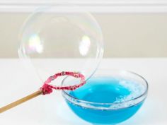 soap bubbles floating in a bowl with a toothpick sticking out of the top